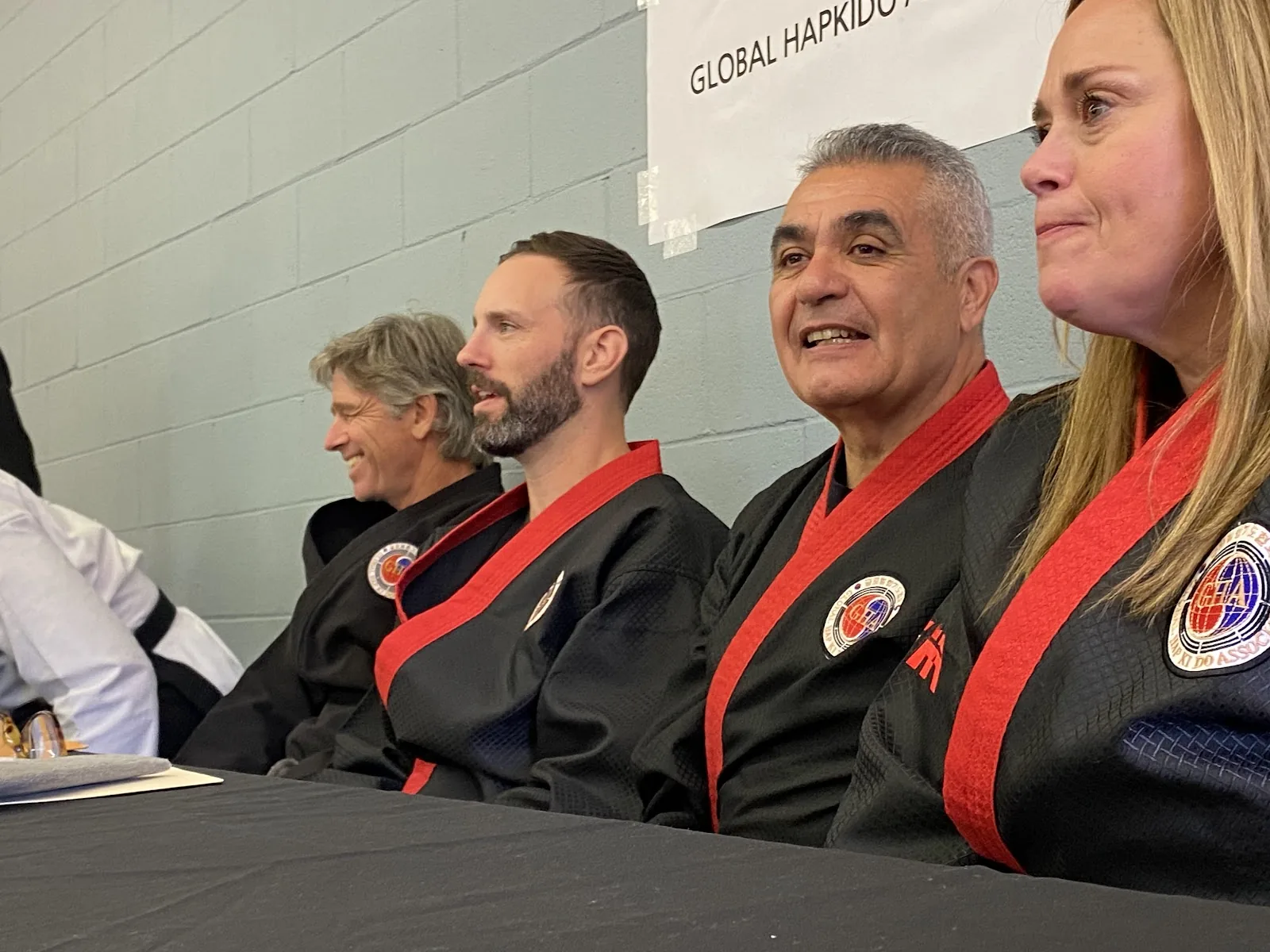 Adults in uniform train together on the mat, some holding focus mitts, at Santa Barbara Dojo