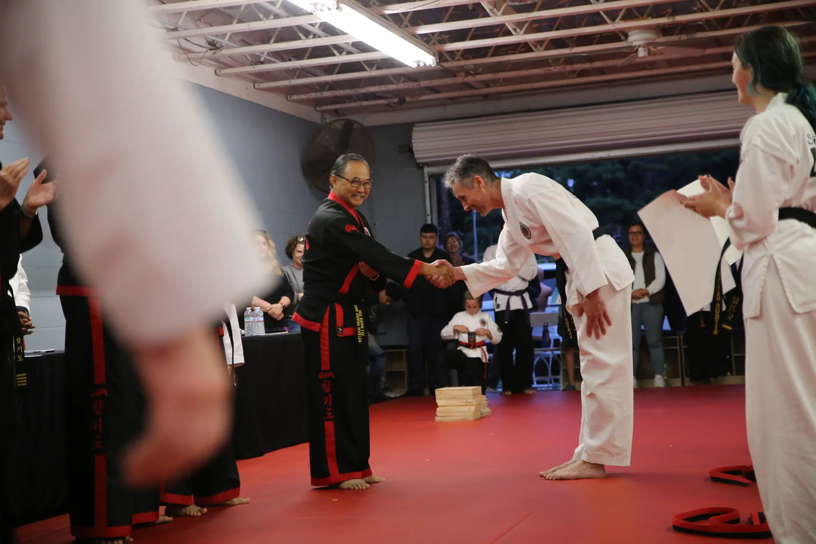 An instructor congratulates a student at the Santa Barbara Dojo black belt test