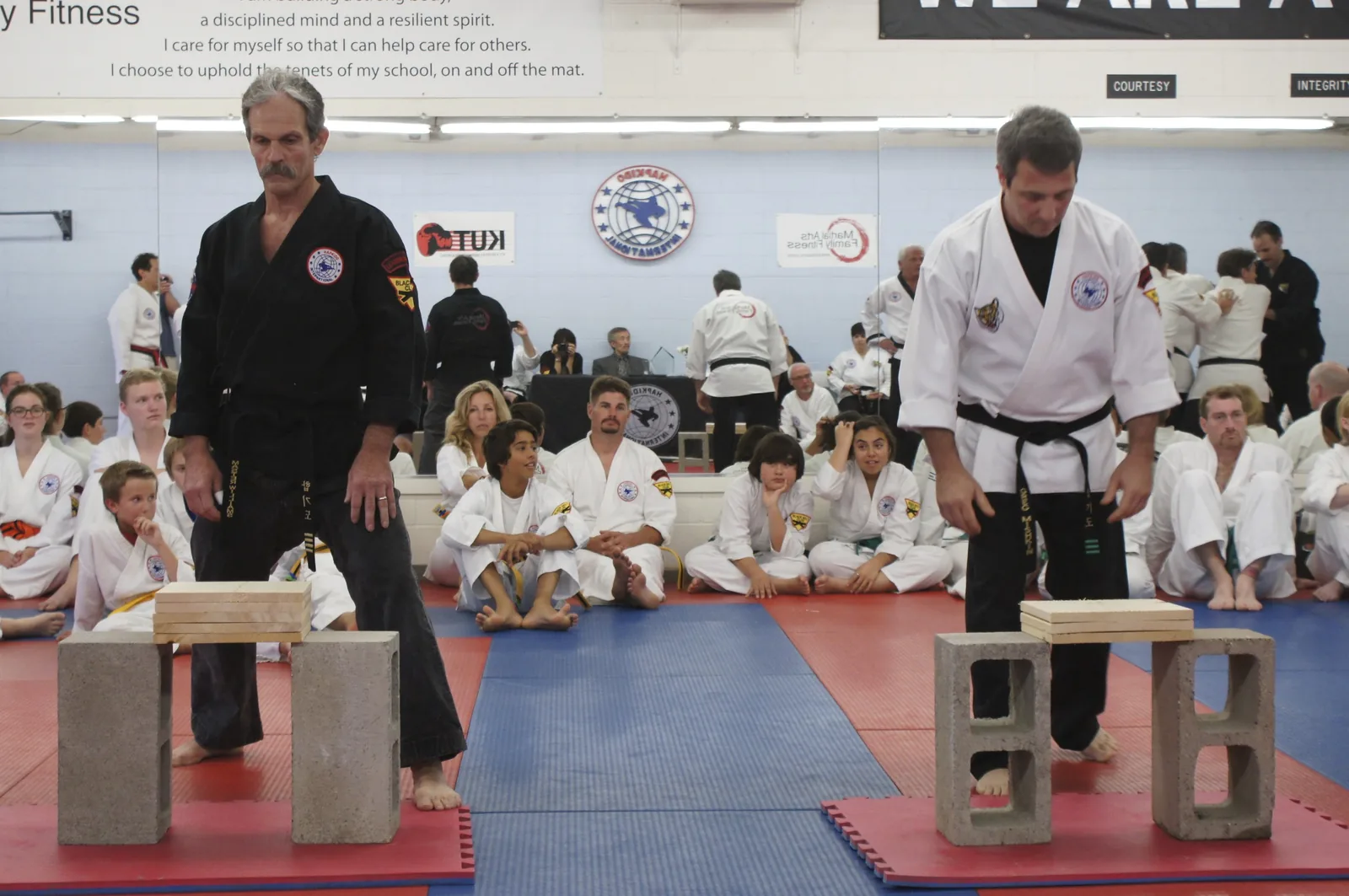 An instructor sets up a board-breaking demonstration in front of students and families