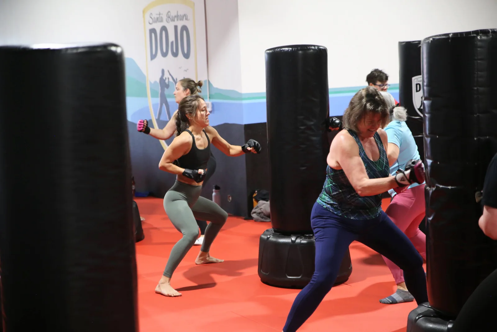 An adult throws a punch at a heavy bag during a heart-rate-tracked kickboxing workout at Santa Barbara Dojo