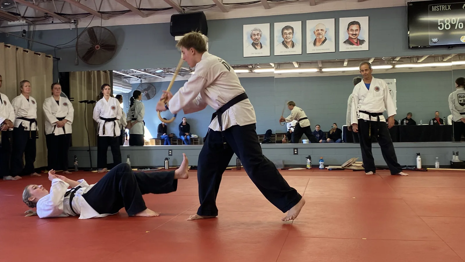 Students practice throws and takedowns on the mat during Black Belt Weekend