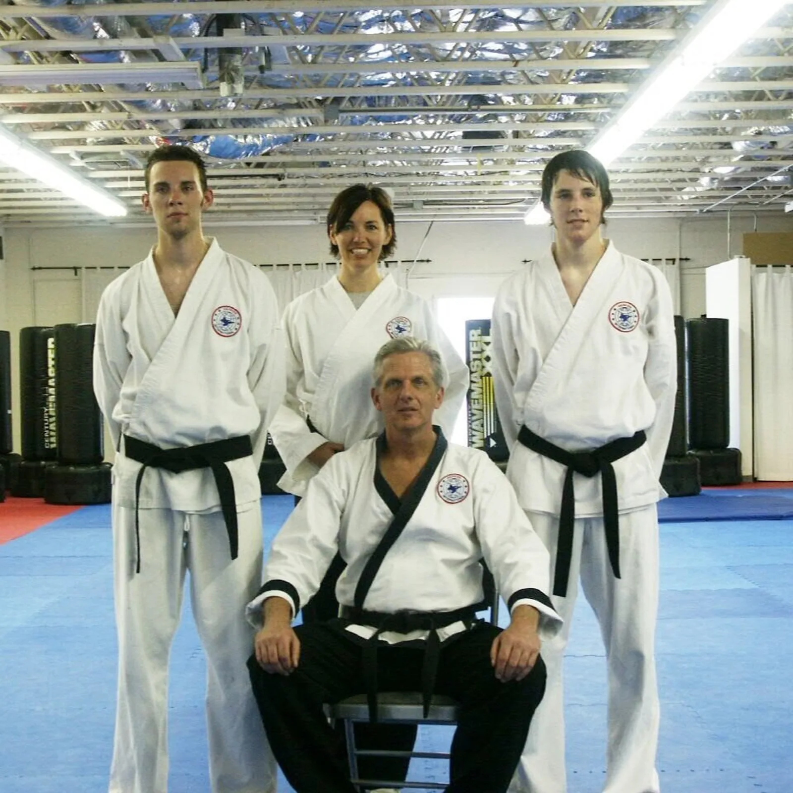 Santa Barbara Dojo black belts in uniform posing together on the mat